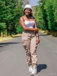 Portrait of smiling young woman standing on road