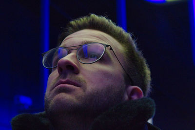 Man looking away in illuminated room