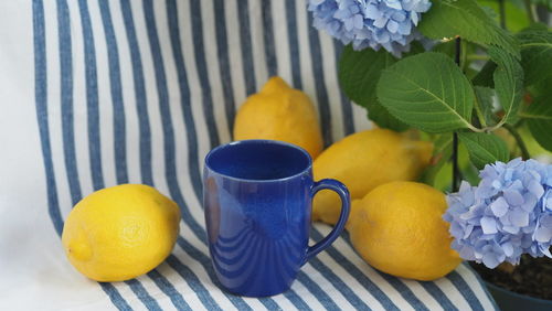 Blue mediterranean coffee mug, bright juicy italian-style lemons blue hydrangeas, travel concept