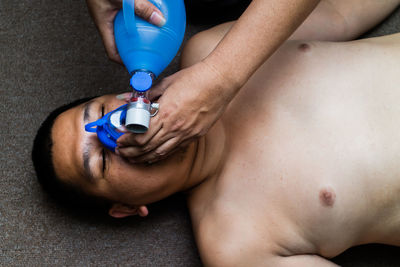 Cropped hands adjusting gas mask of man