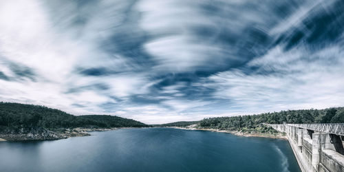 Scenic view of dam against sky with clouds.