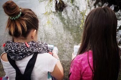 Rear view of women using mobile phones