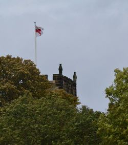 Low angle view of flag on built structure against sky