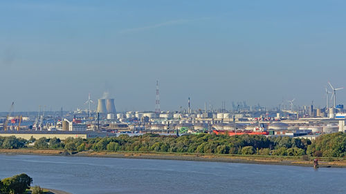 Scenic view of sea by buildings against sky