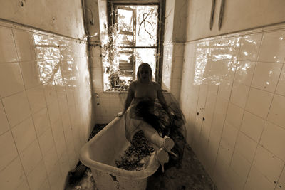 Woman sitting in abandoned room