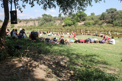 People relaxing on grassy landscape