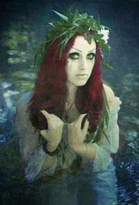 Portrait of young woman with plants in foreground