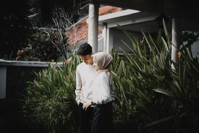 A couple standing by plants