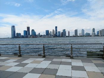 Modern buildings by sea against sky in city