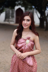 Portrait of a smiling young woman standing outdoors