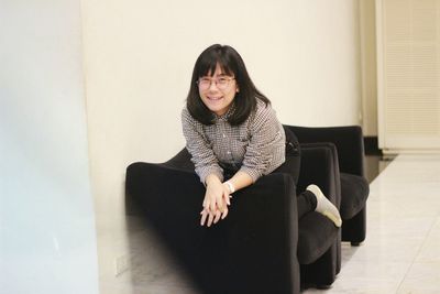 Portrait of smiling young woman sitting at home