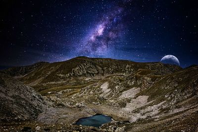 Scenic view of mountain against sky at night