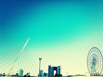 Low angle view of ferris wheel against blue sky