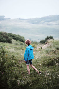 Rear view of woman walking on field