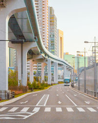 Road by modern buildings against sky in city