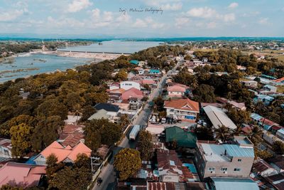 High angle view of town by sea against sky