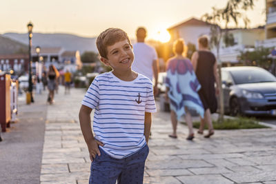 Portrait of teenage boy standing on street in city