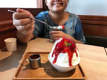 Woman eating ice cream at table