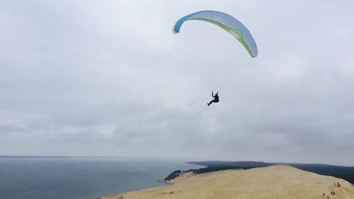 Low angle view of paragliding over sea against sky