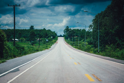 Road amidst trees against sky