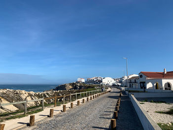 Panoramic view of sea and buildings against blue sky