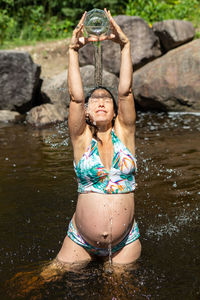 Midsection of woman in bikini in water