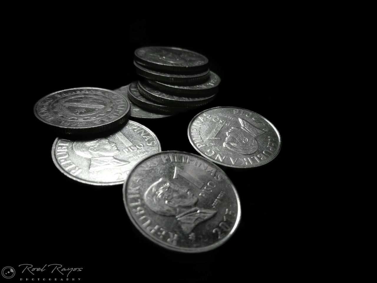 CLOSE-UP OF COINS IN BLACK BACKGROUND