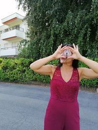 Midsection of woman standing by road in city