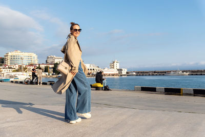 Full length of woman standing on road against sky