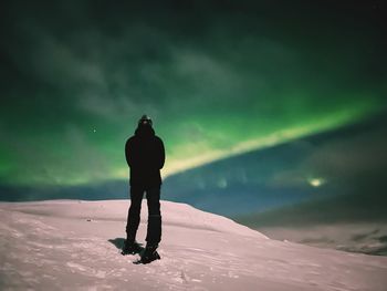 Rear view of man walking on snow