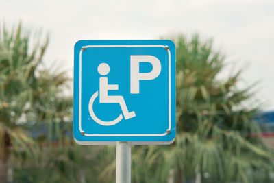 Close-up of road sign against blue sky