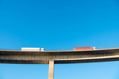 Low angle view of bridge against clear blue sky