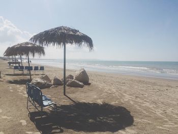 Umbrellas on beach against sky
