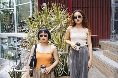 Portrait of young woman wearing sunglasses standing outdoors