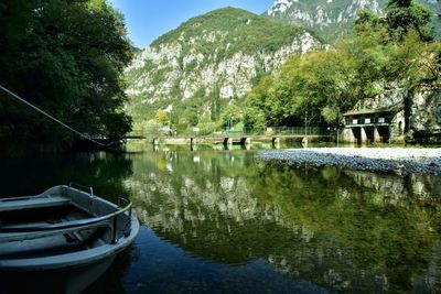 Boats moored in lake against trees