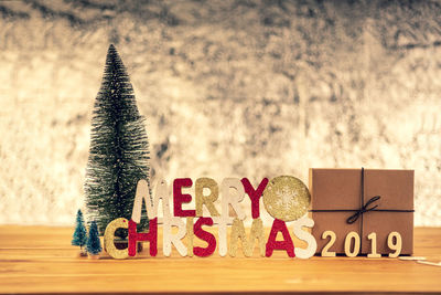 Close-up of christmas tree and text on table