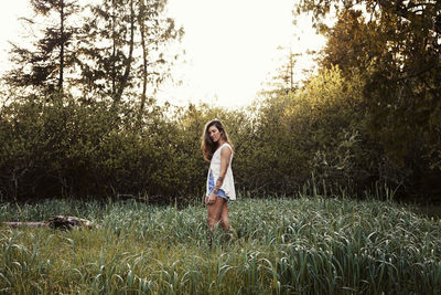 Full length portrait of young woman on field