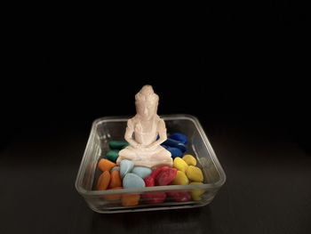 Close-up of multi colored candies on table against black background