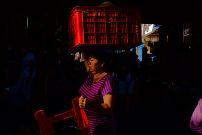 Full length of woman looking at while standing at night