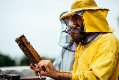 Beekeeper working over beehive at farm