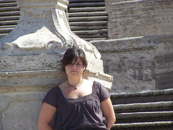 Portrait of young woman standing on steps