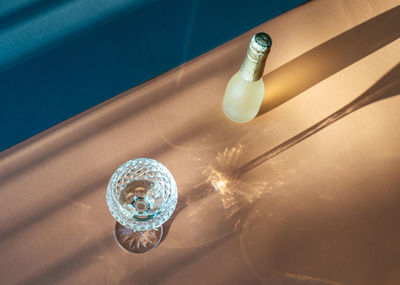 High angle view of bottle and wineglass on table