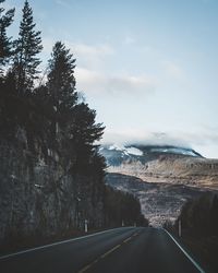 Road amidst trees against sky