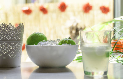 Caipirinha by limes and ice in bowl on table