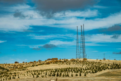 Electricity pylon on field against sky