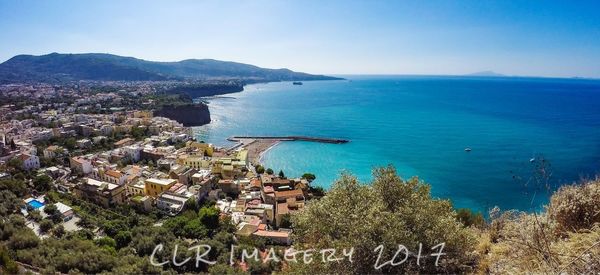 High angle view of town by sea against clear sky