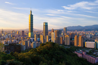 Buildings in city against cloudy sky