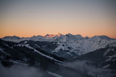 Scenic view of snow covered mountains against sky during sunset