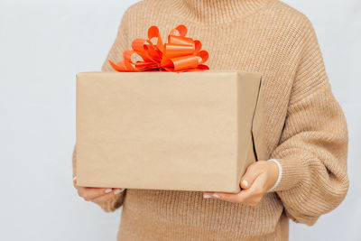 Midsection of woman with gift box against white background