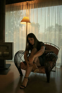 Portrait of woman sitting on sofa at home